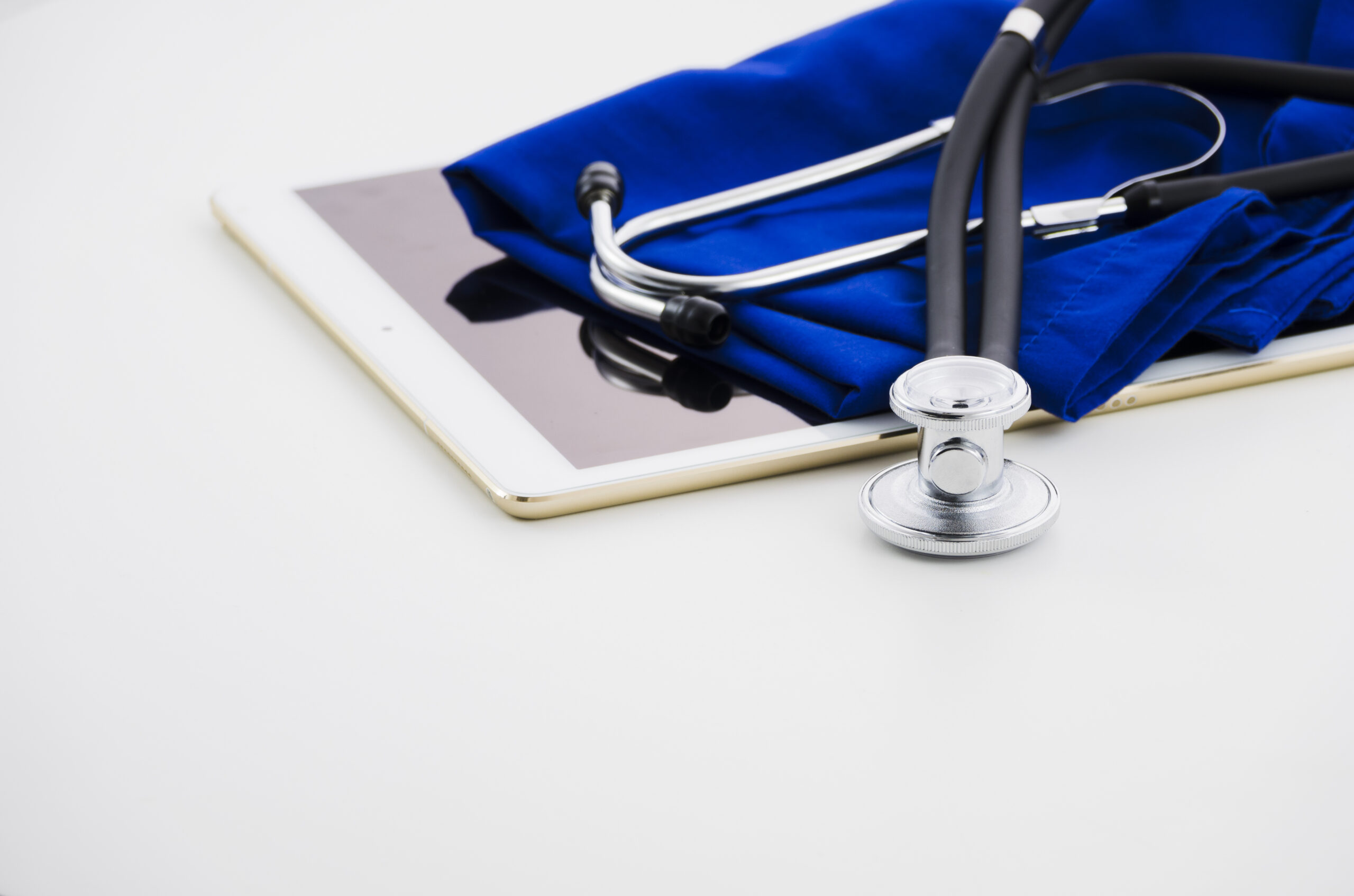 digital-tablet-stethoscope-medical-gown-white-backdrop